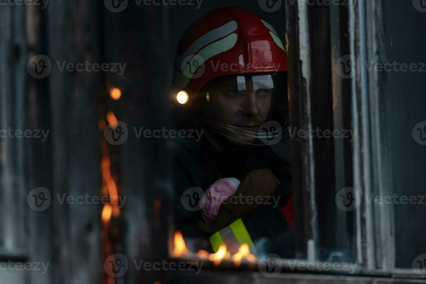 brandman hjälte bärande bebis flicka ut från brinnande byggnad område från brand incident. rädda människor från farlig plats foto