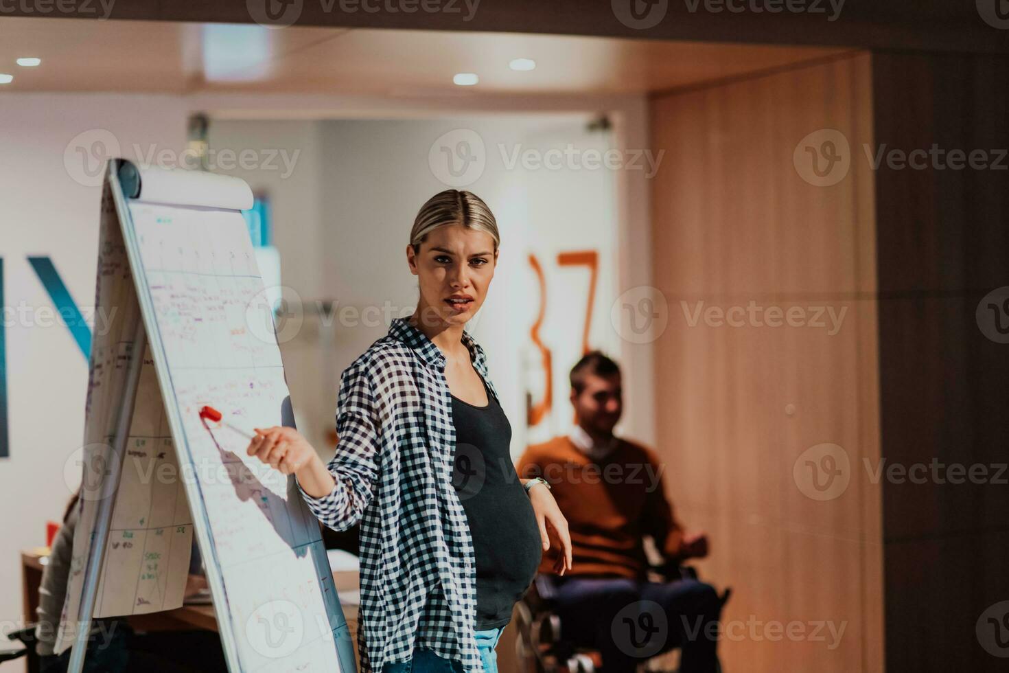 en gravid affärskvinna leder en kreativ möte av en olika företag team i en modern coworking foto