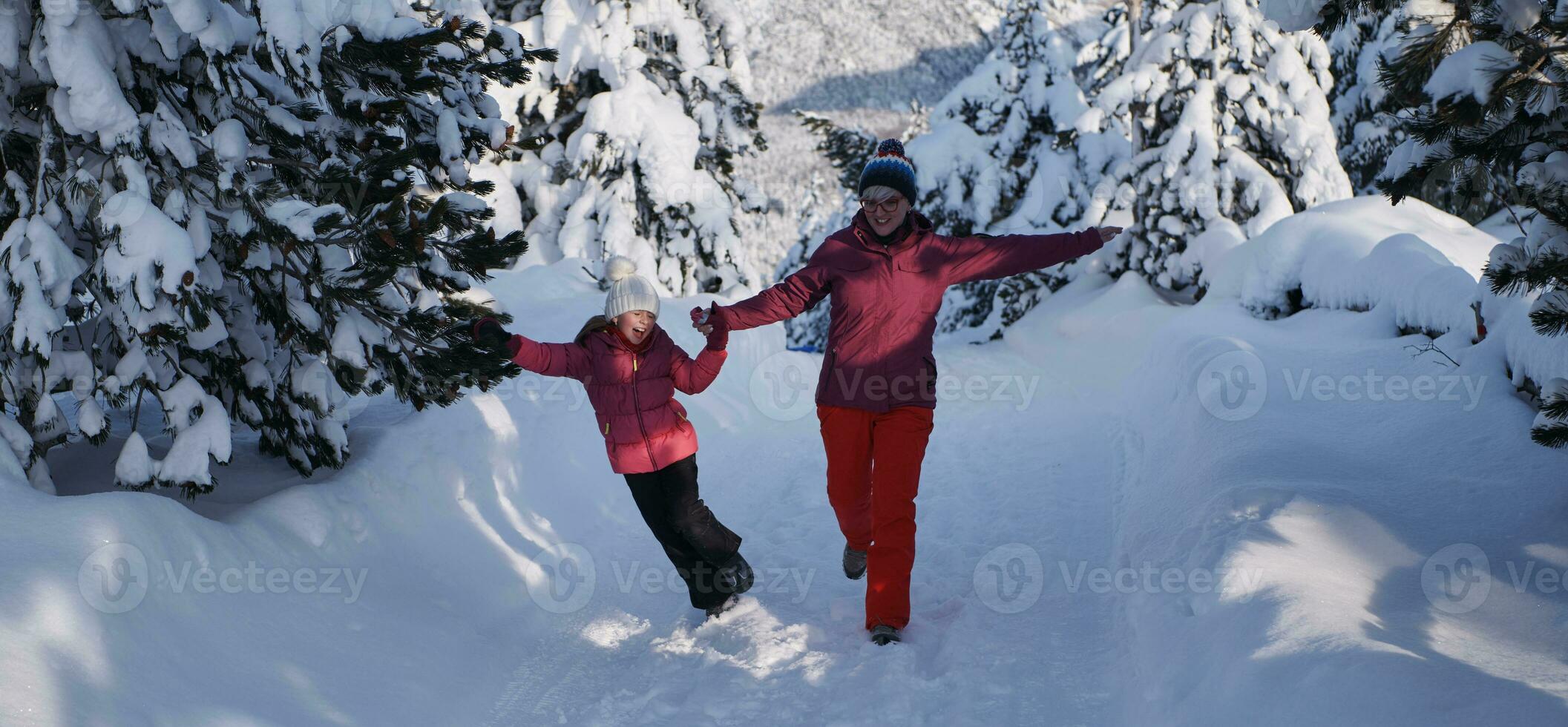 mor och dotter gående på skön solig vinter- dag foto