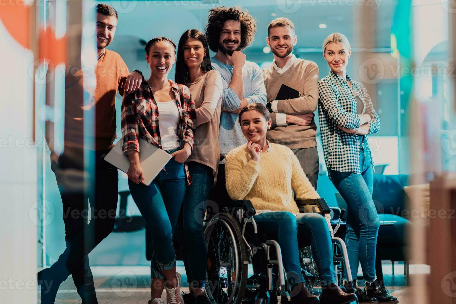 affärskvinna i en rullstol på ha sönder i en modern kontor med henne team i de bakgrund foto