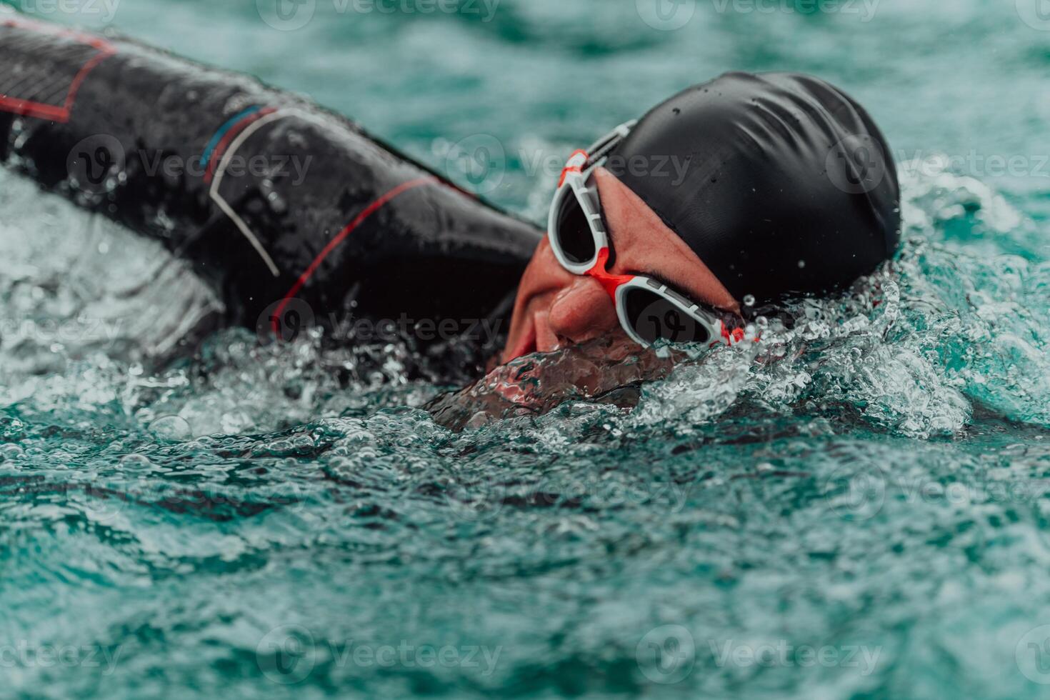 en triathlete i en professionell simning kostym tåg på de flod medan framställning för olympic simning foto