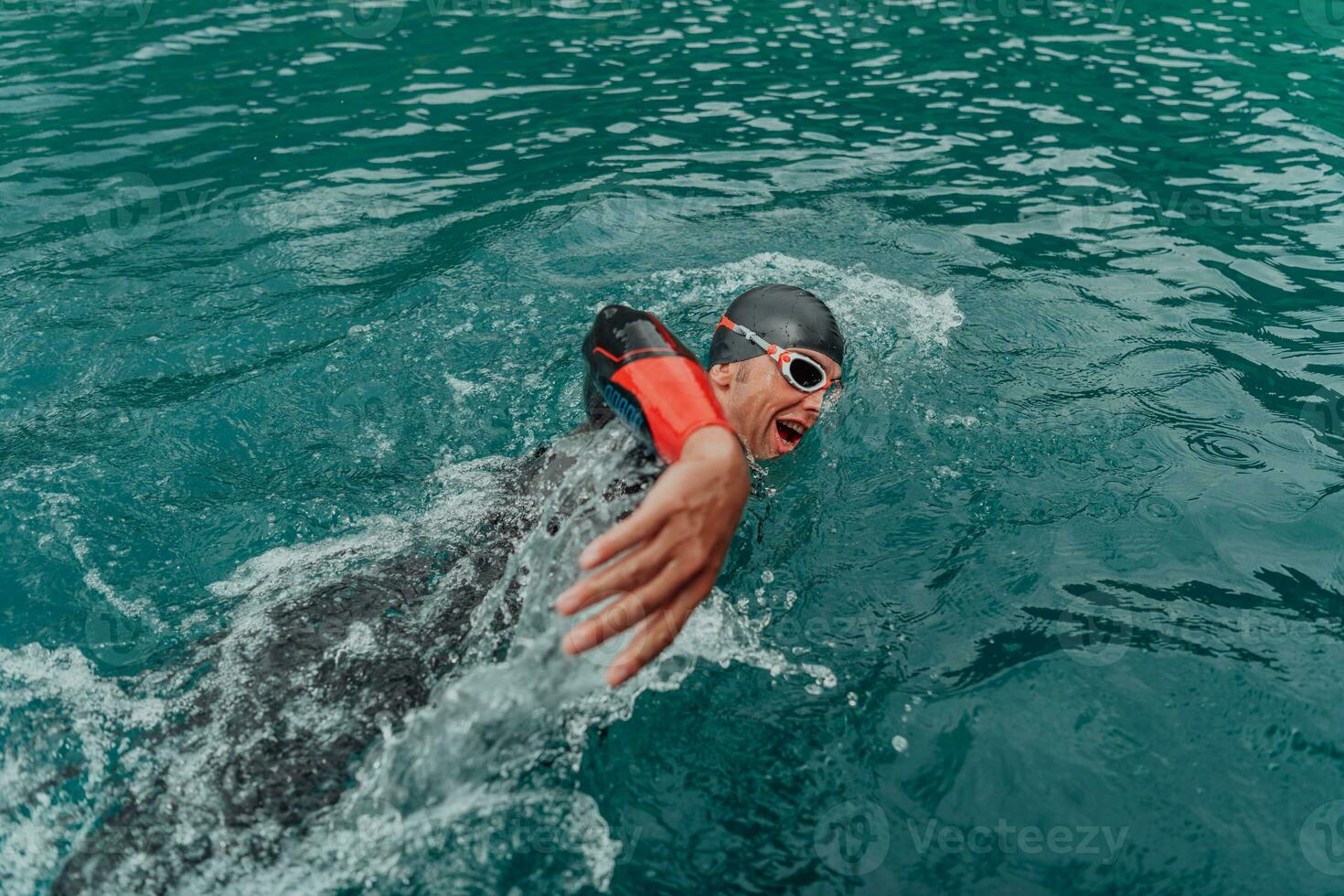 en triathlete i en professionell simning kostym tåg på de flod medan framställning för olympic simning foto