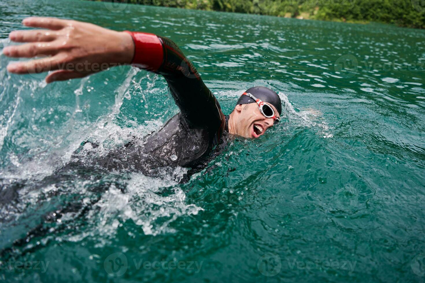 triathlon idrottare simmar på sjön bär våtdräkt foto