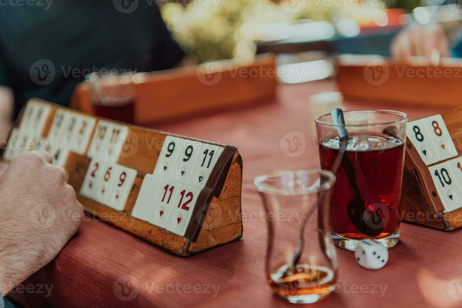 en grupp av män dryck traditionell turkiska te och spela en turkiska spel kallad okej foto