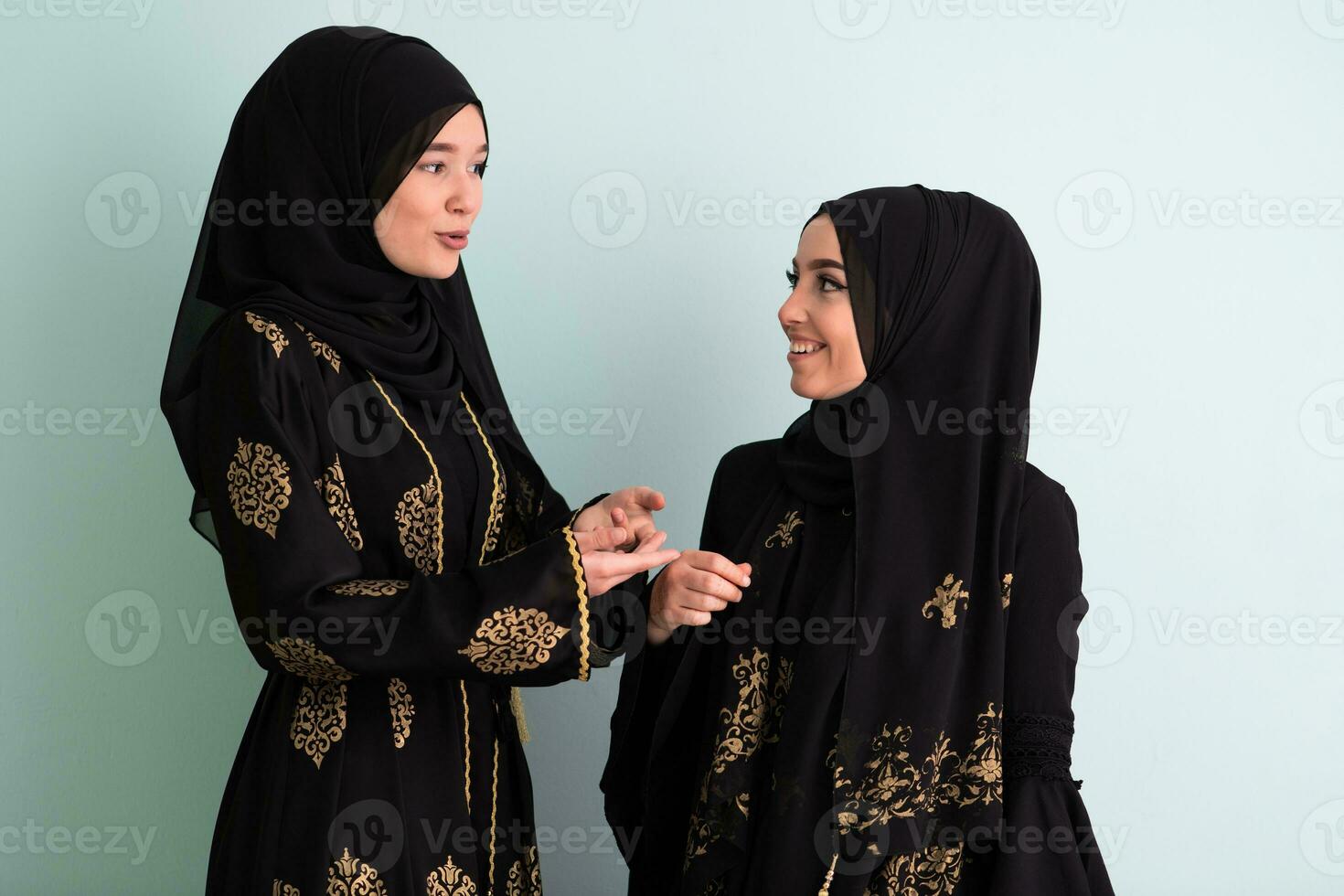 två skön muslim kvinna i fasinable klänning med hijab isolerat på modern cyan bakgrund representerar begrepp av modern islam och ramadan kareem foto