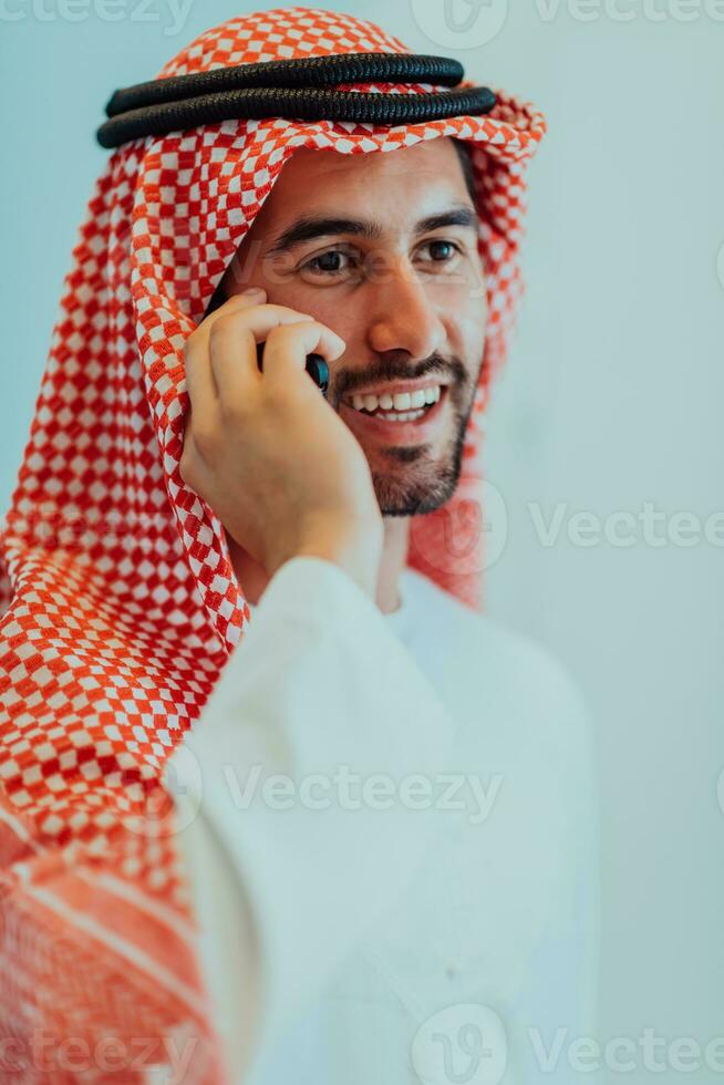 ung modern muslim arab affärsmän bär traditionell kläder medan använder sig av smartphones på Hem. foto