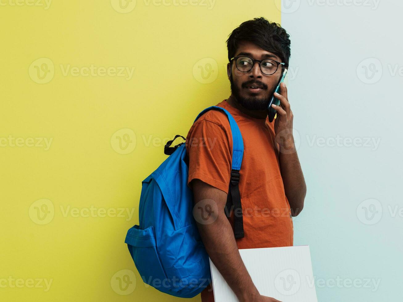 indisk studerande med blå ryggsäck, glasögon och anteckningsbok Framställ på grå och grön bakgrund. de begrepp av utbildning och skolutbildning. tid till gå tillbaka till skola foto