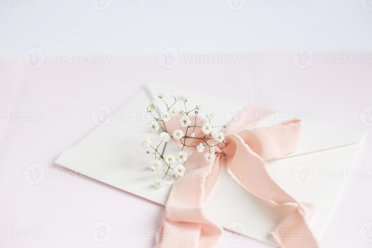 kuvert på en vit-rosa bakgrund med persika silkesband och rosa foto