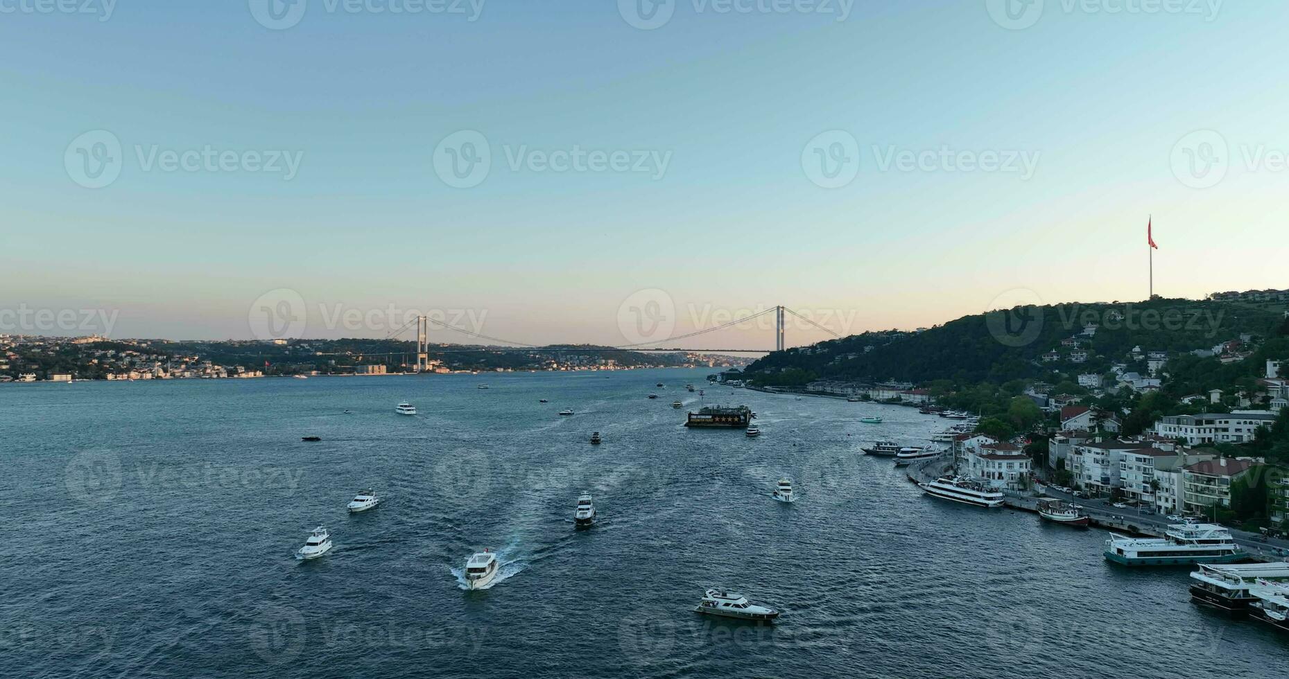 istanbul bosphorus bro och stad horisont i bakgrund med turkiska flagga på skön solnedgång, antenn glida kretsande och spårning skott foto