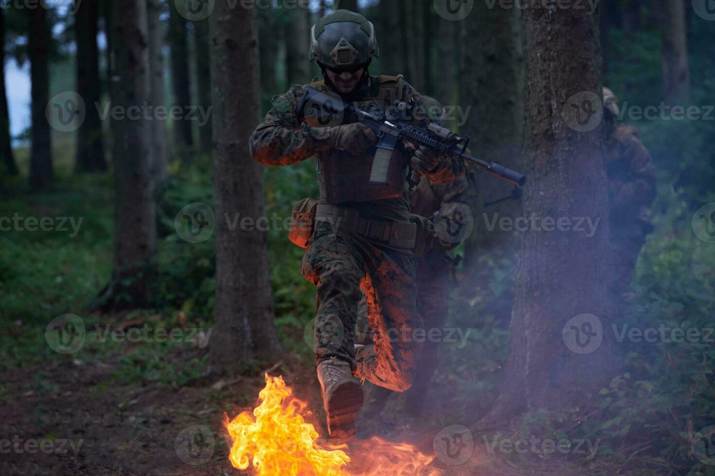 soldat i verkan på natt Hoppar över brand foto