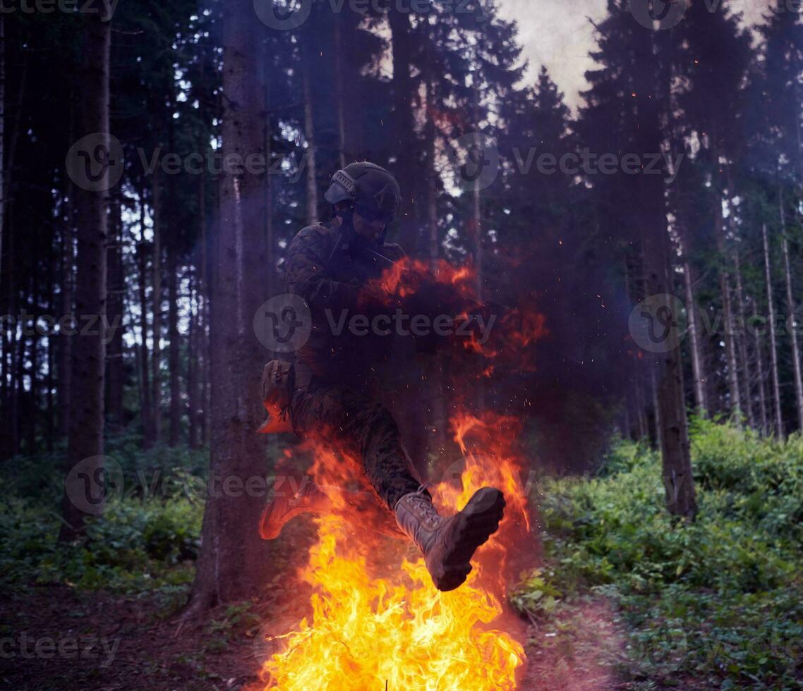 soldat i verkan på natt Hoppar över brand foto