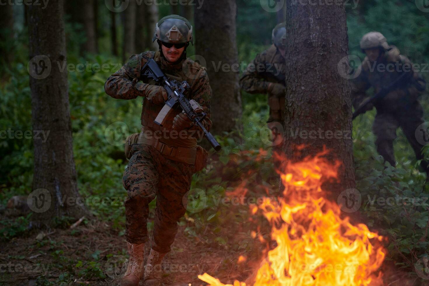 soldat i verkan på natt Hoppar över brand foto