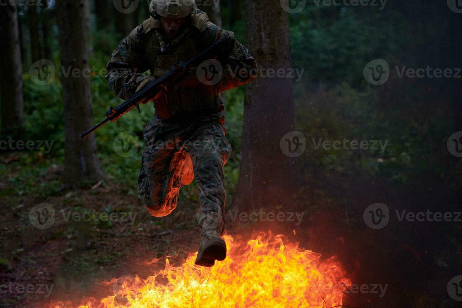 soldat i verkan på natt Hoppar över brand foto