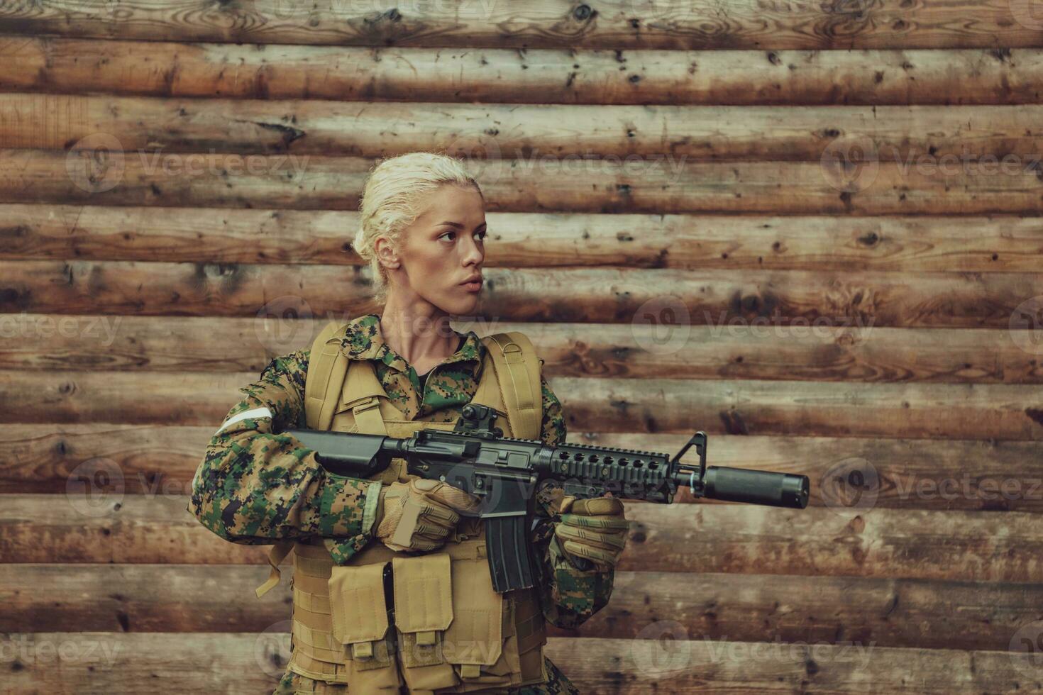 kvinna soldat redo för slåss bär skyddande militär redskap och vapen foto