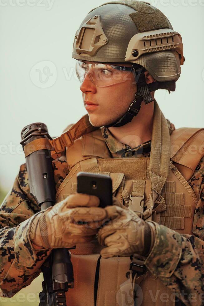 soldat använder sig av smartphone till Kontakt familj eller flickvän kommunikation och nostalgi begrepp foto