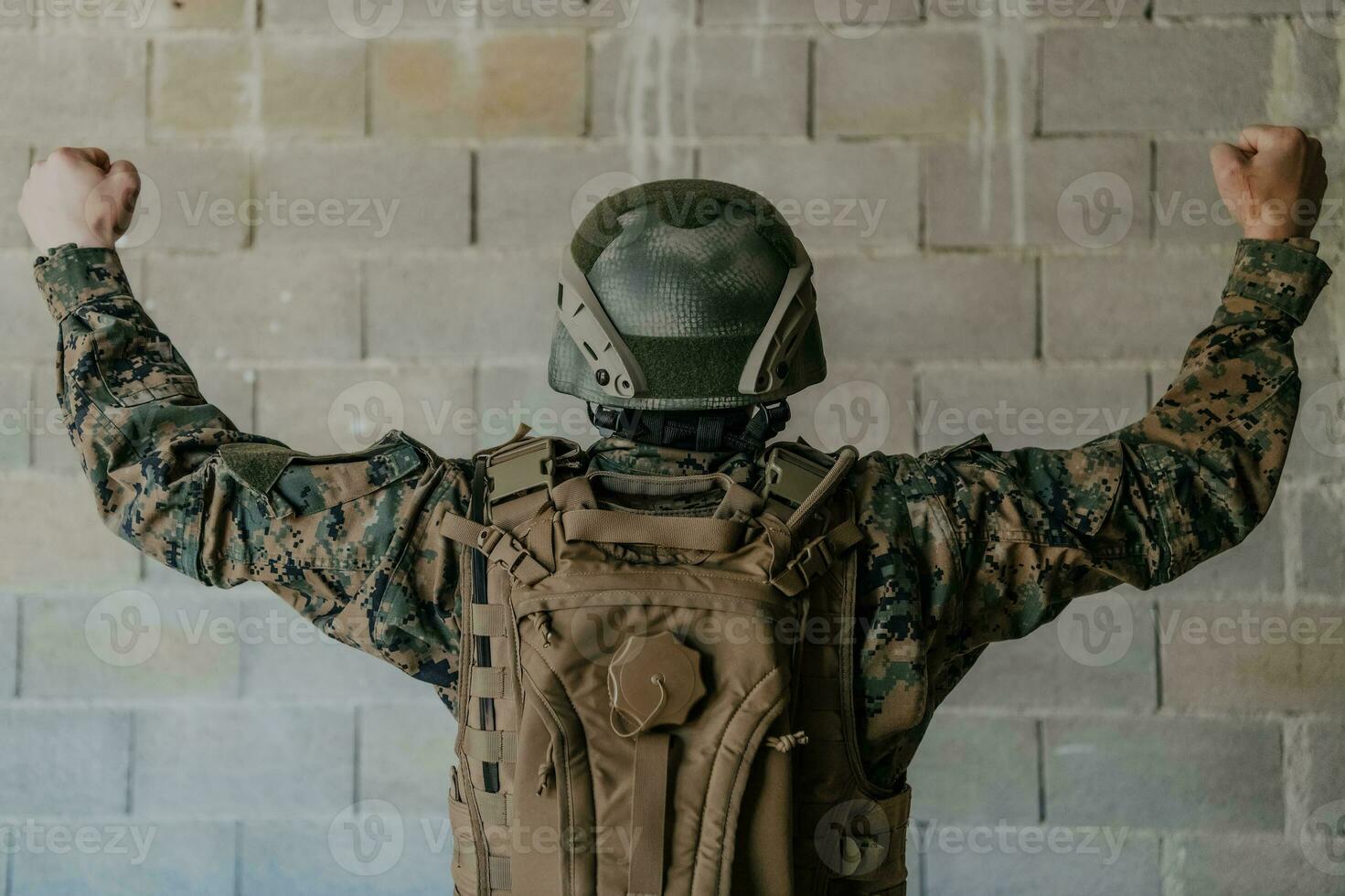 Framgång i de krig kampanj. en soldat med Uppfostrad händer firar de framgångsrik erövring av fiende territorium foto