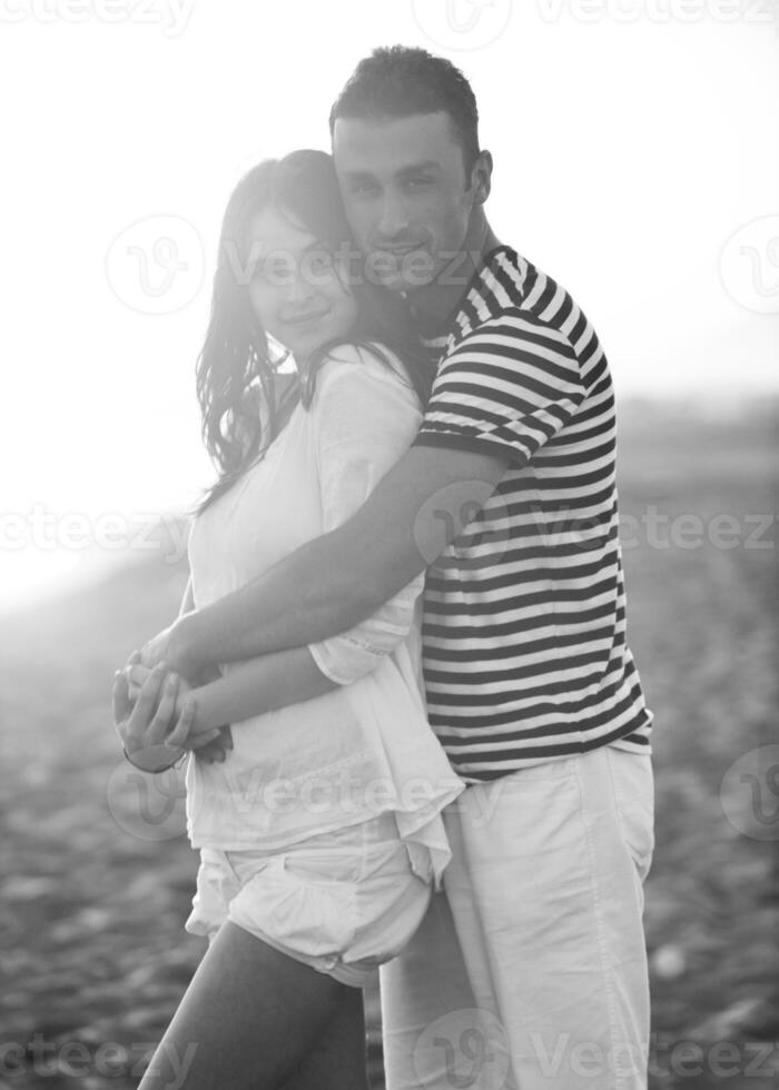 Lycklig ung par ha romantisk tid på strand foto