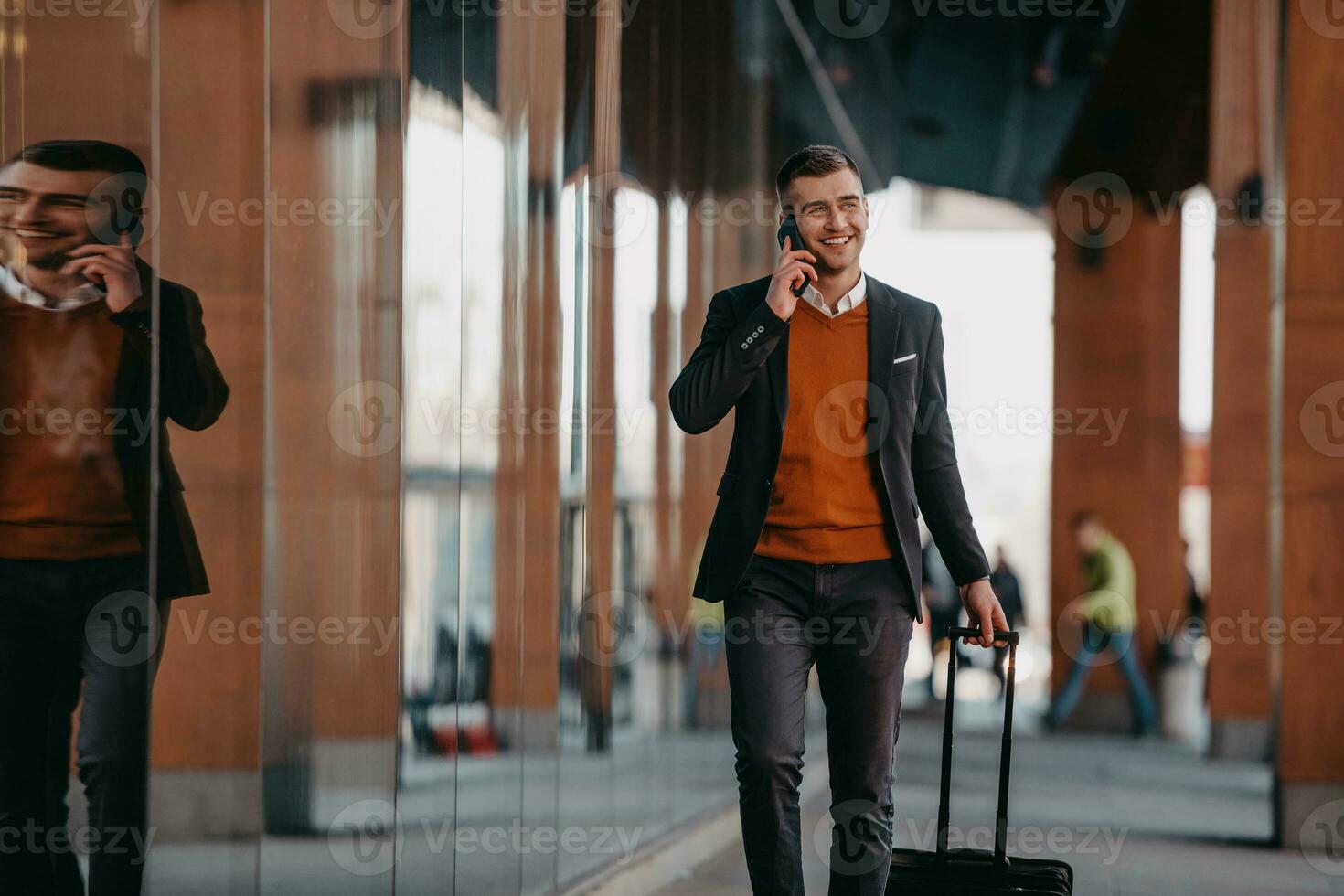 gående till flygplats terminal. självsäker affärsman resande gående på stad gator och dragande hans resväska dricka kaffe och tala på smartphone foto