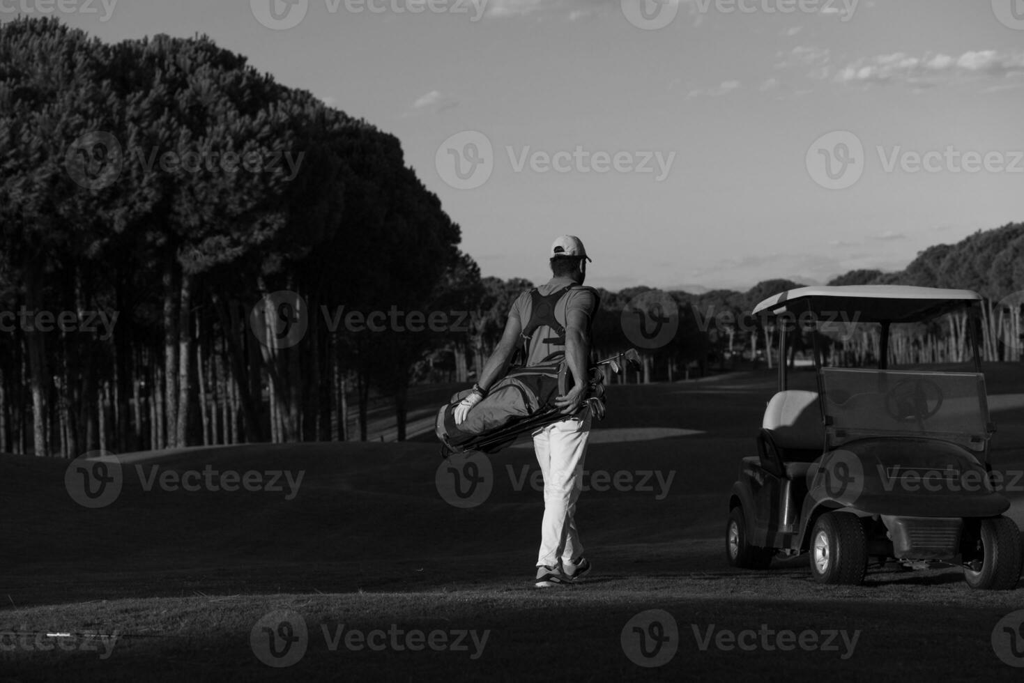golfspelare gående och bärande golf väska foto