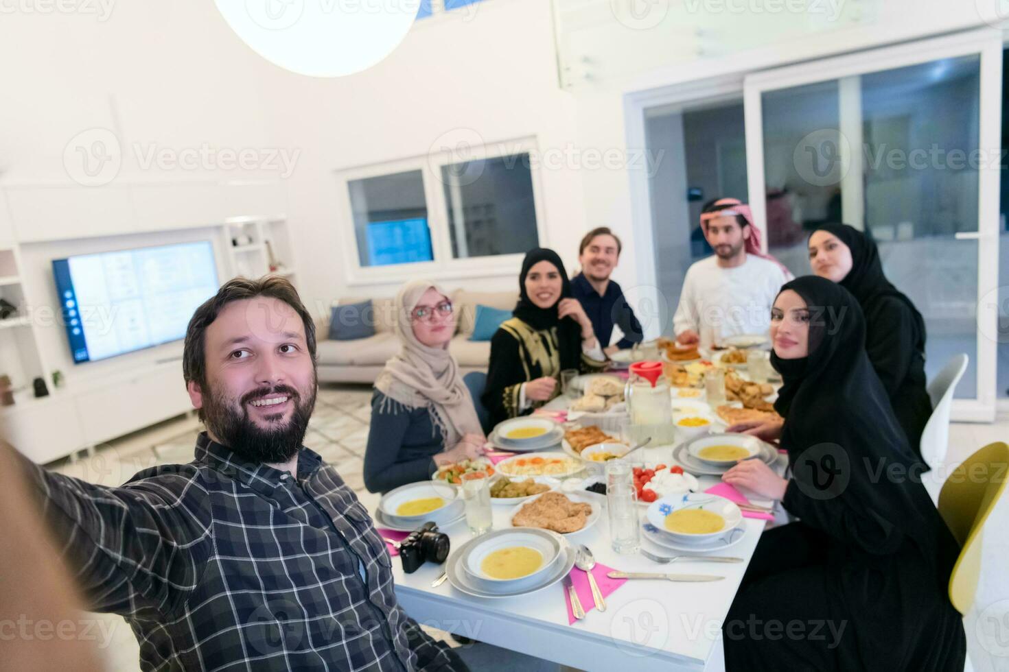 eid mubarak muslim familj har iftar middag tar bilder med mobil telefon medan äter traditionell mat under ramadan festande månad på Hem. de islamic halal äter och dricka islamic famil foto