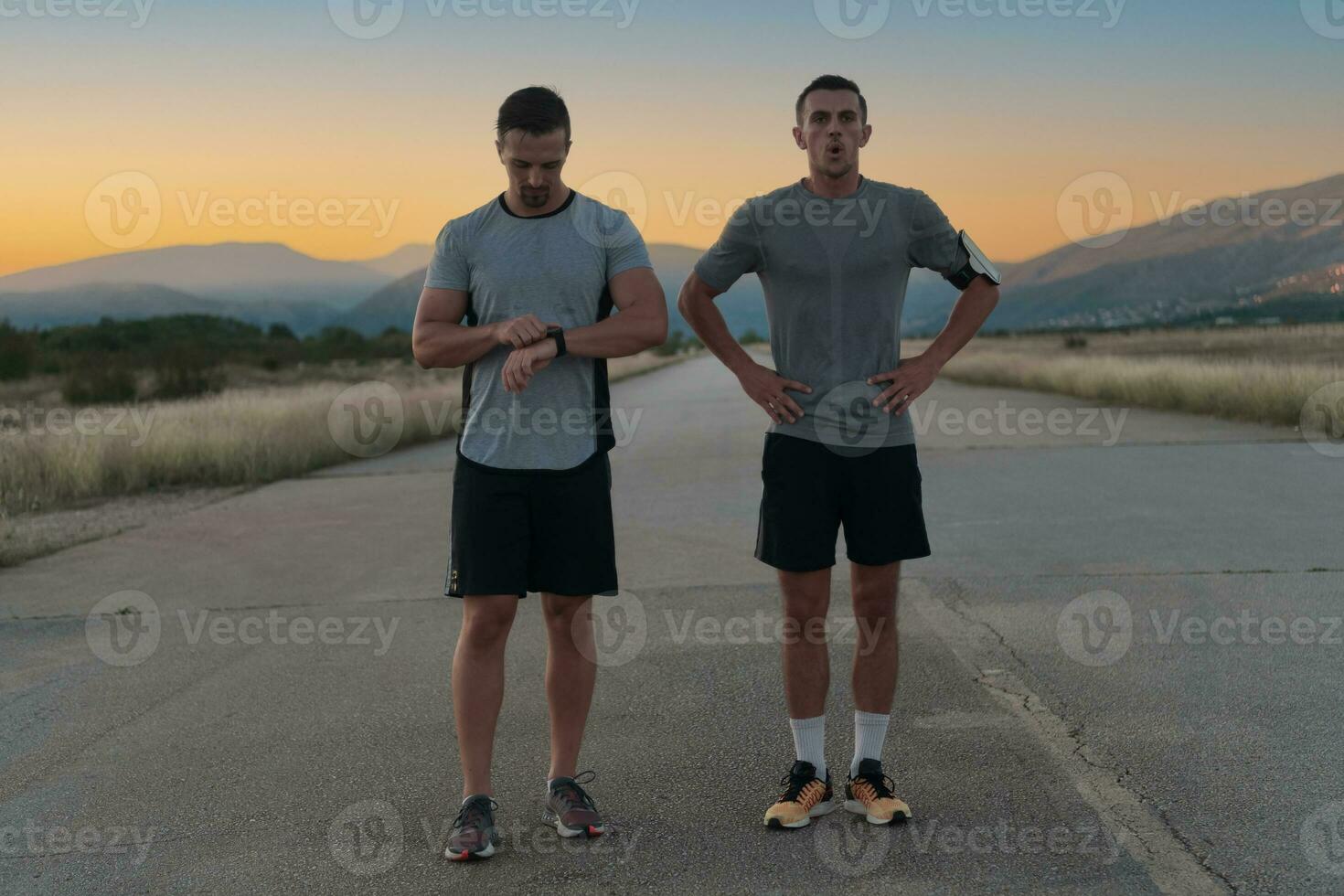 sport par ser på en smart klocka medan stående på de Land väg. vilar efter joggning och löpning övning och kontroll hjärta Betygsätta och puls. foto