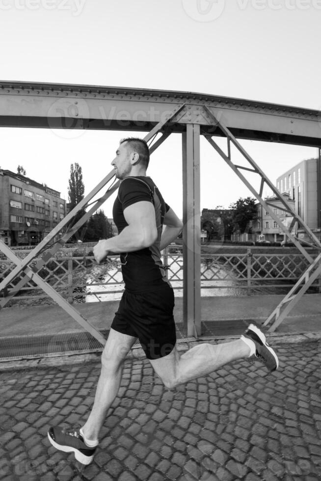 man joggar över bron på solig morgon foto