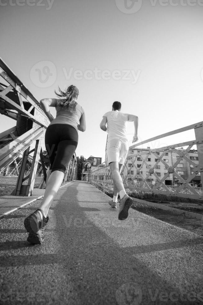 ungt par joggar över bron i staden foto