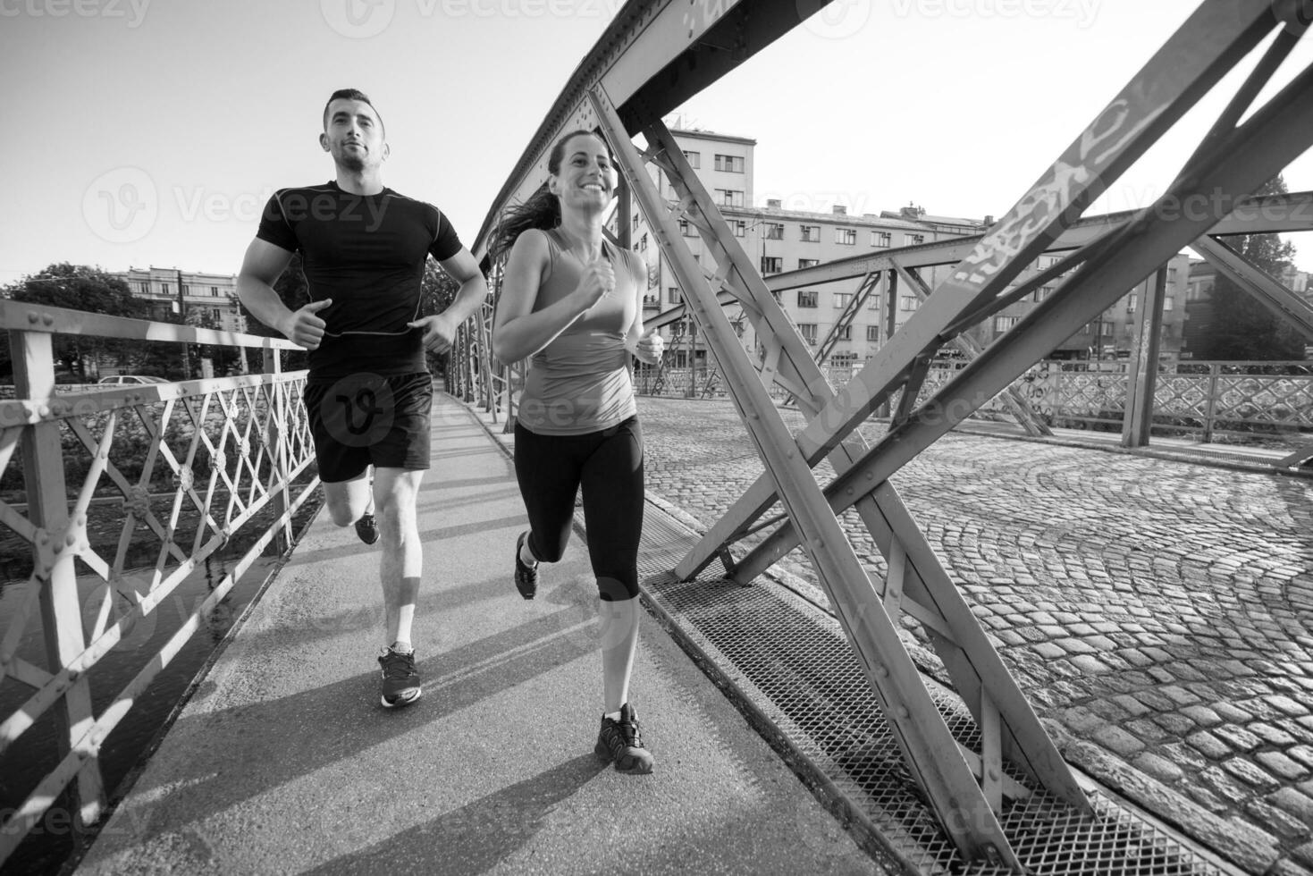 ungt par joggar över bron i staden foto