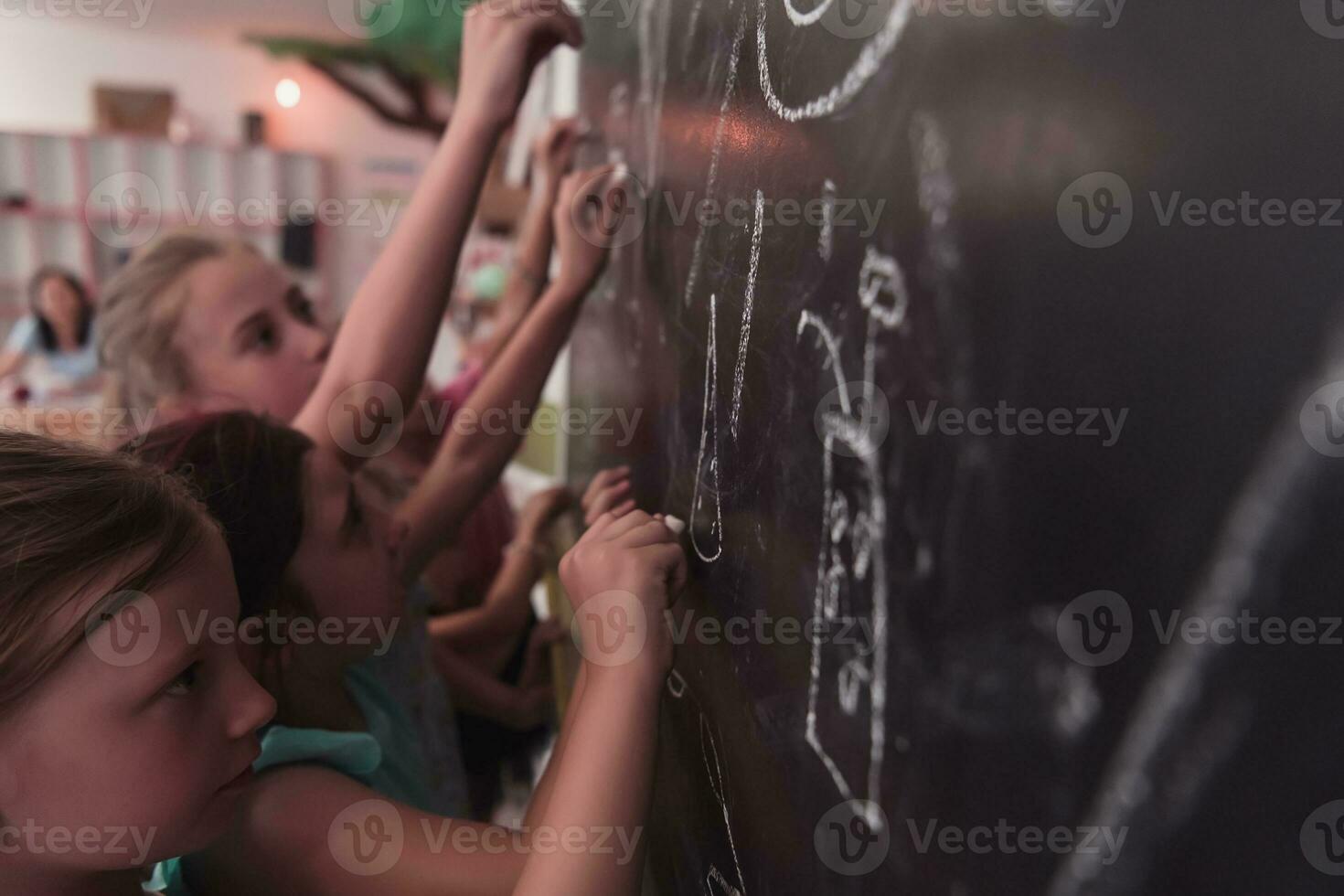 barn skriva och dra på de svarta tavlan i elementärt skola medan inlärning de grunderna av utbildning foto