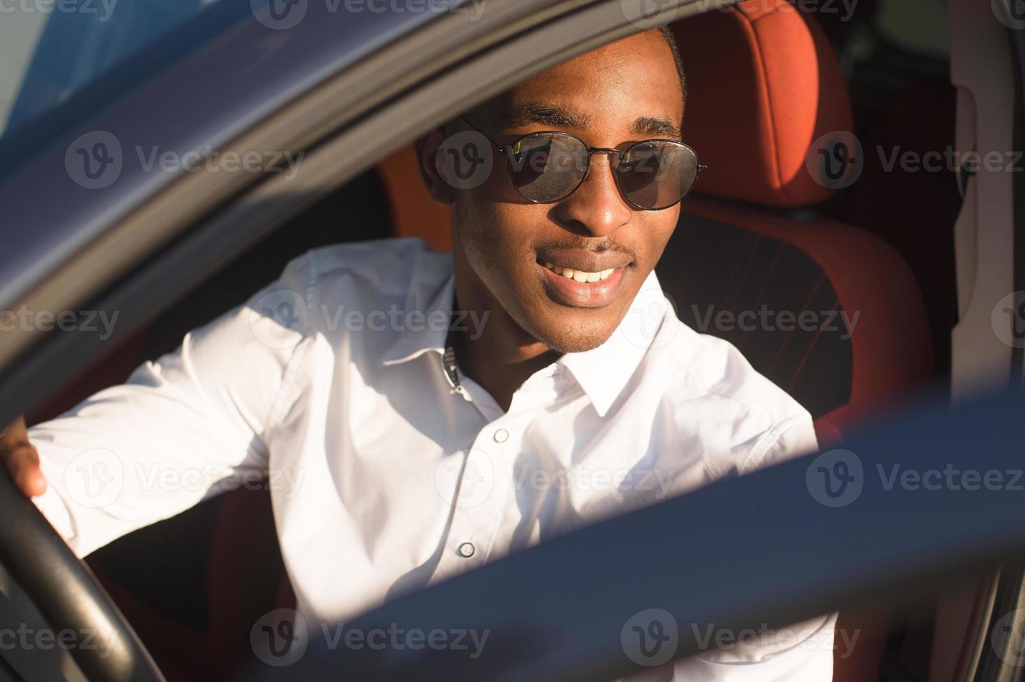 glad afroamerikan som kör bil, på sommaren foto