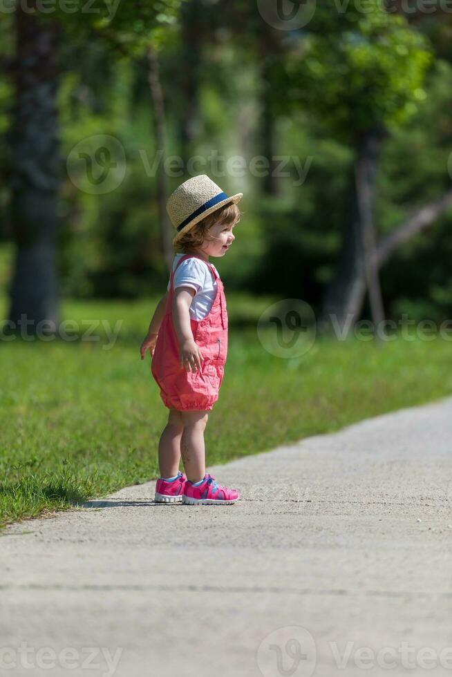 liten flicka springer i sommarparken foto