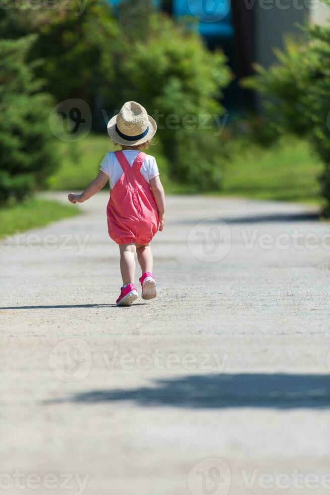 liten flicka springer i sommarparken foto