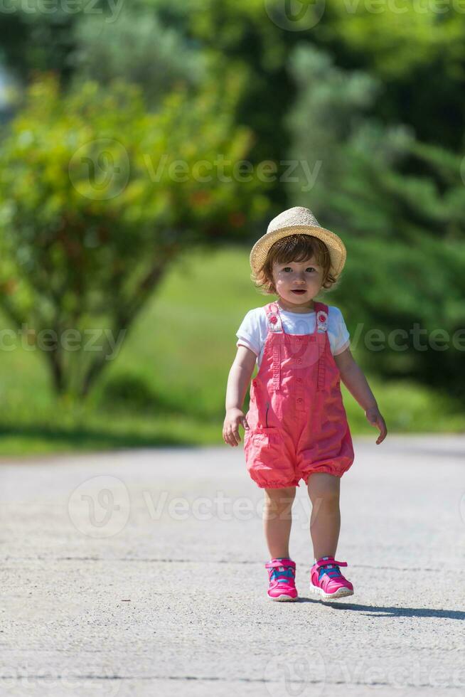 liten flicka springer i sommarparken foto