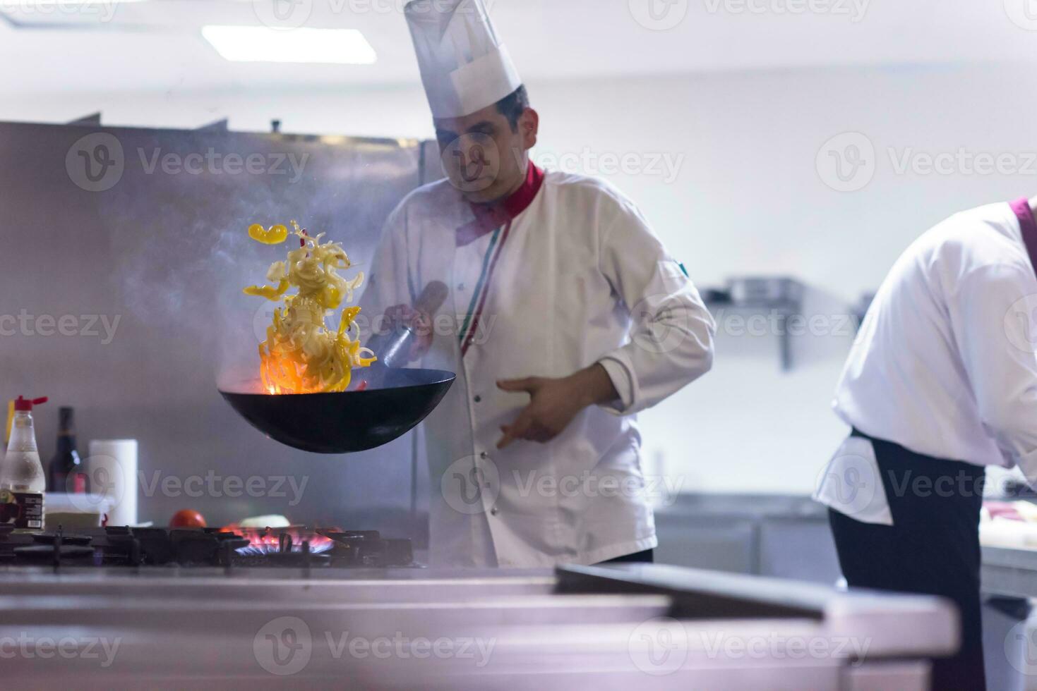 kock vända grönsaker i wok foto