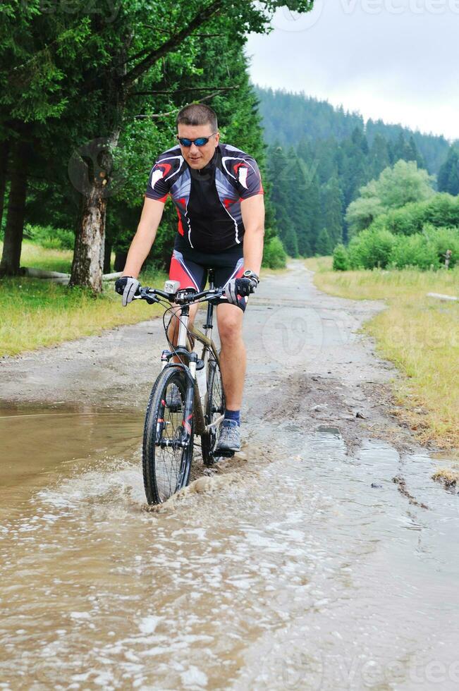 våt montera cykel rida foto