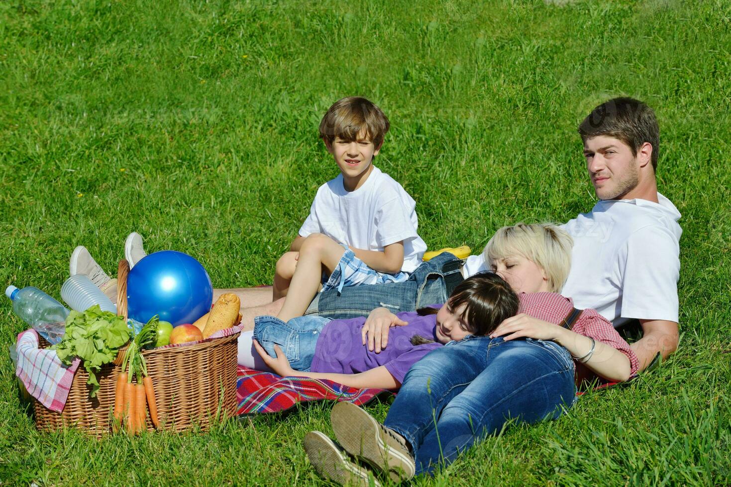 Lycklig familj spelar tillsammans i en picknick utomhus foto