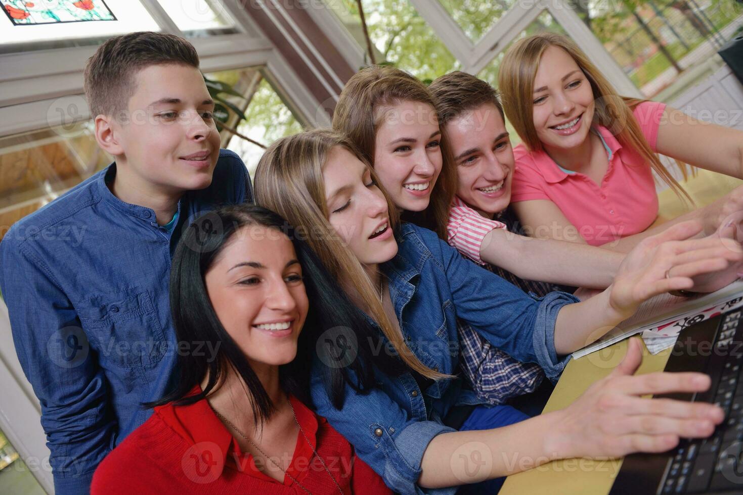 Lycklig tonåren grupp i skola foto