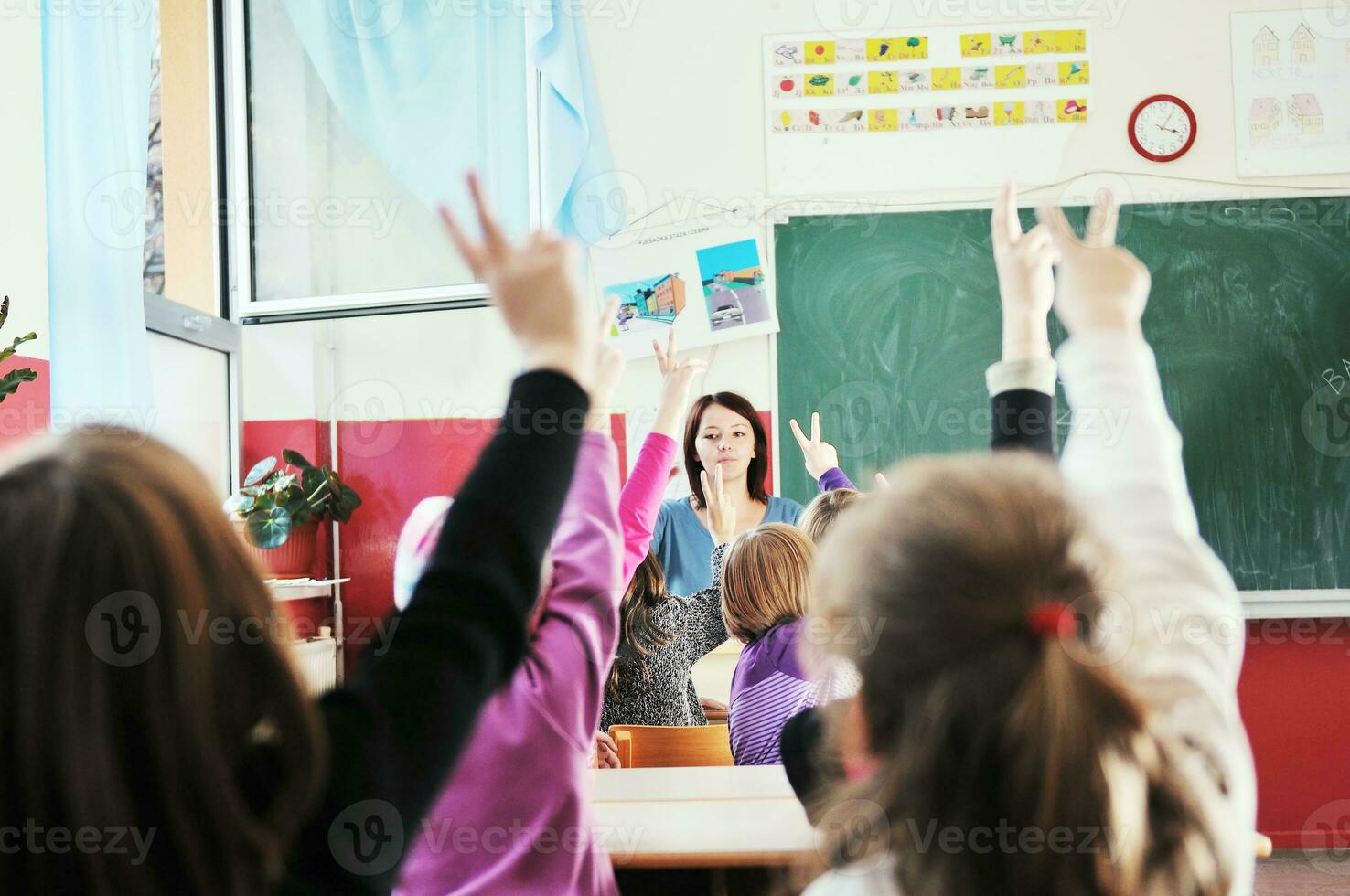 Lycklig barn med lärare i skola klassrum foto