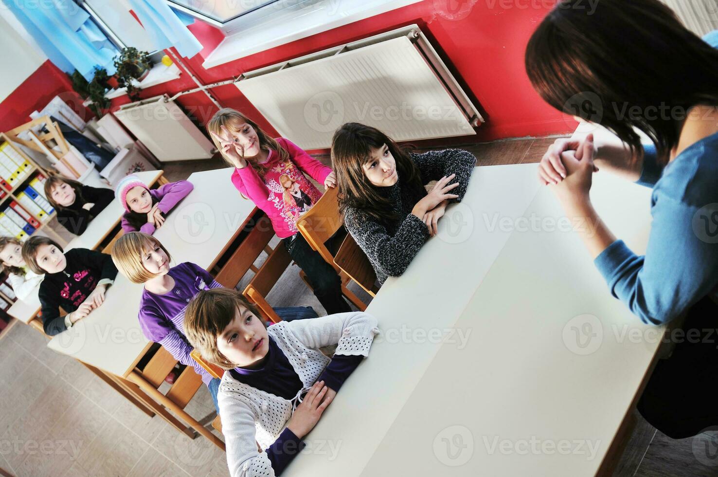 Lycklig barn med lärare i skola klassrum foto
