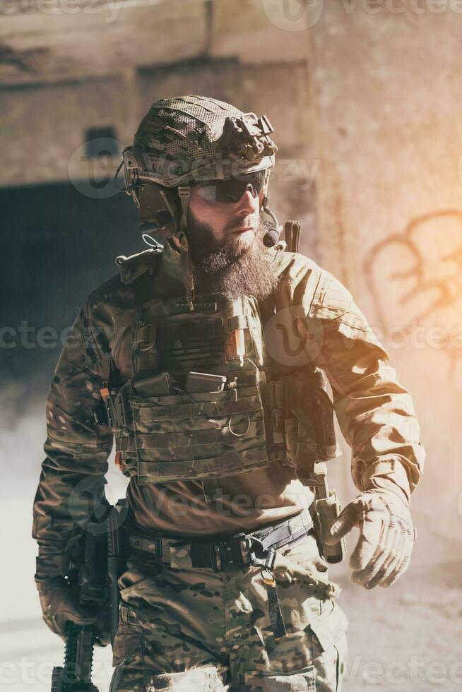 en skäggig soldat i en särskild krafter enhetlig promenader genom ett övergiven byggnad efter en framgångsrik uppdrag. urval fokus foto