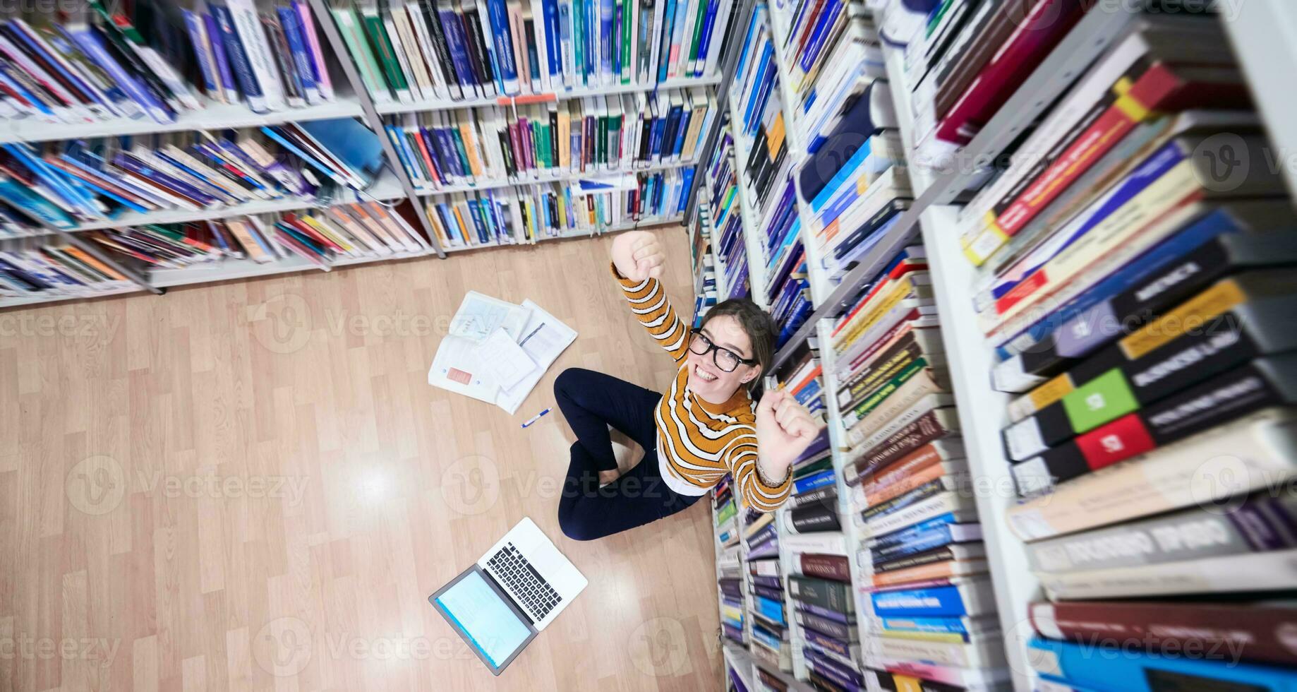 de studerande användningar en anteckningsbok och en skola bibliotek foto