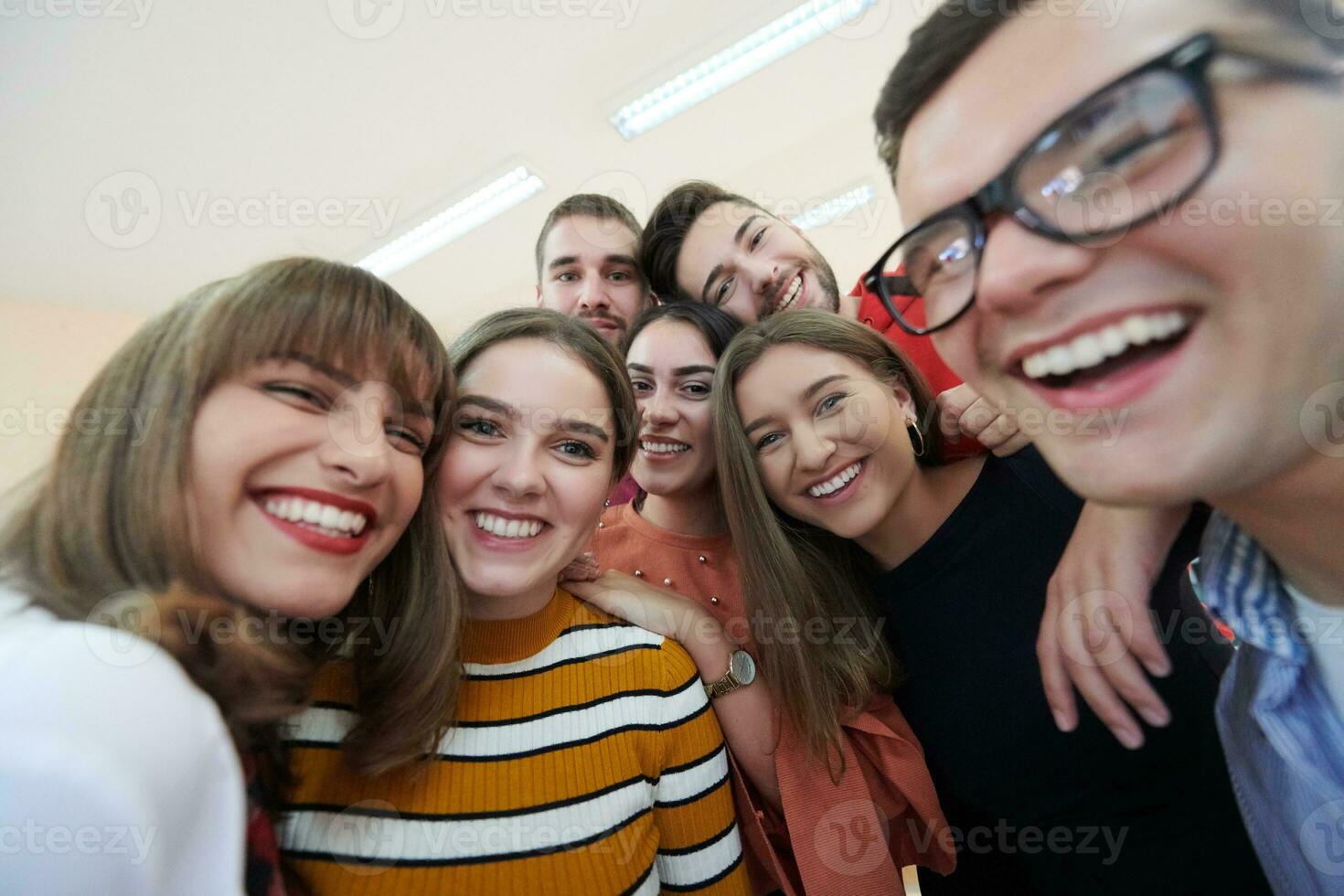 grupp av multietnisk tonåringar tar en selfie i skola foto