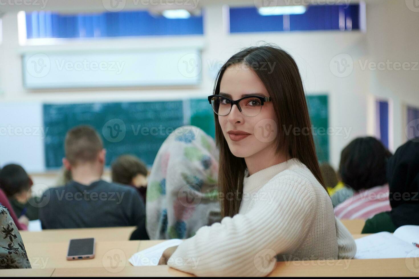 flicka Sammanträde i ett amfiteater och talande till henne kollegor foto