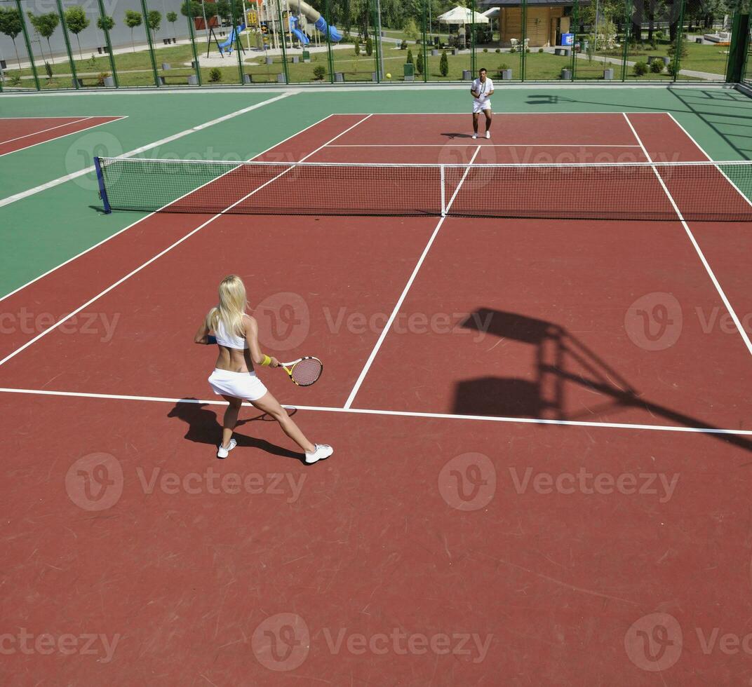 ung kvinna spela tennisspel utomhus foto