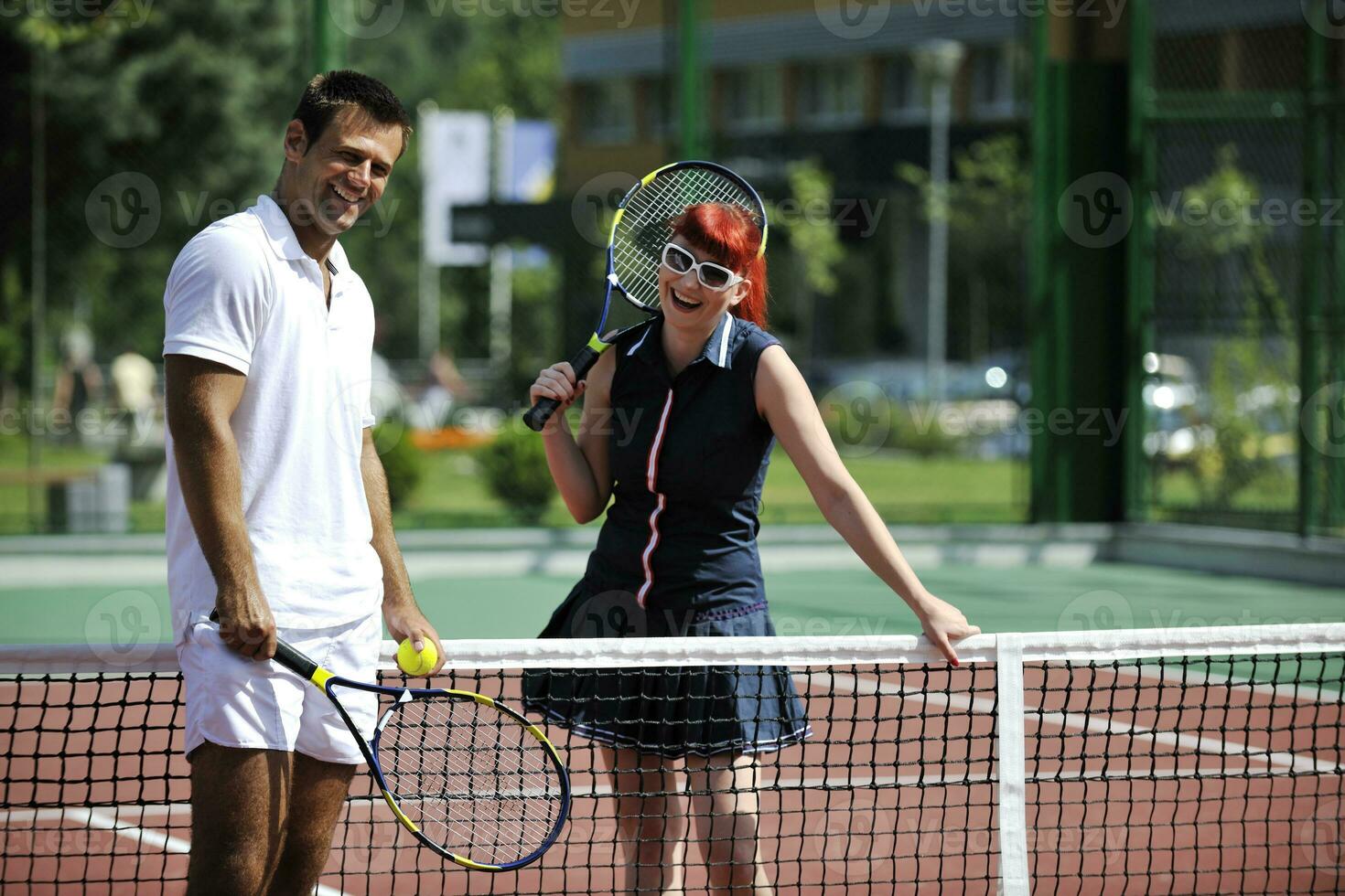 Lycklig ung par spela tennis spel utomhus- foto