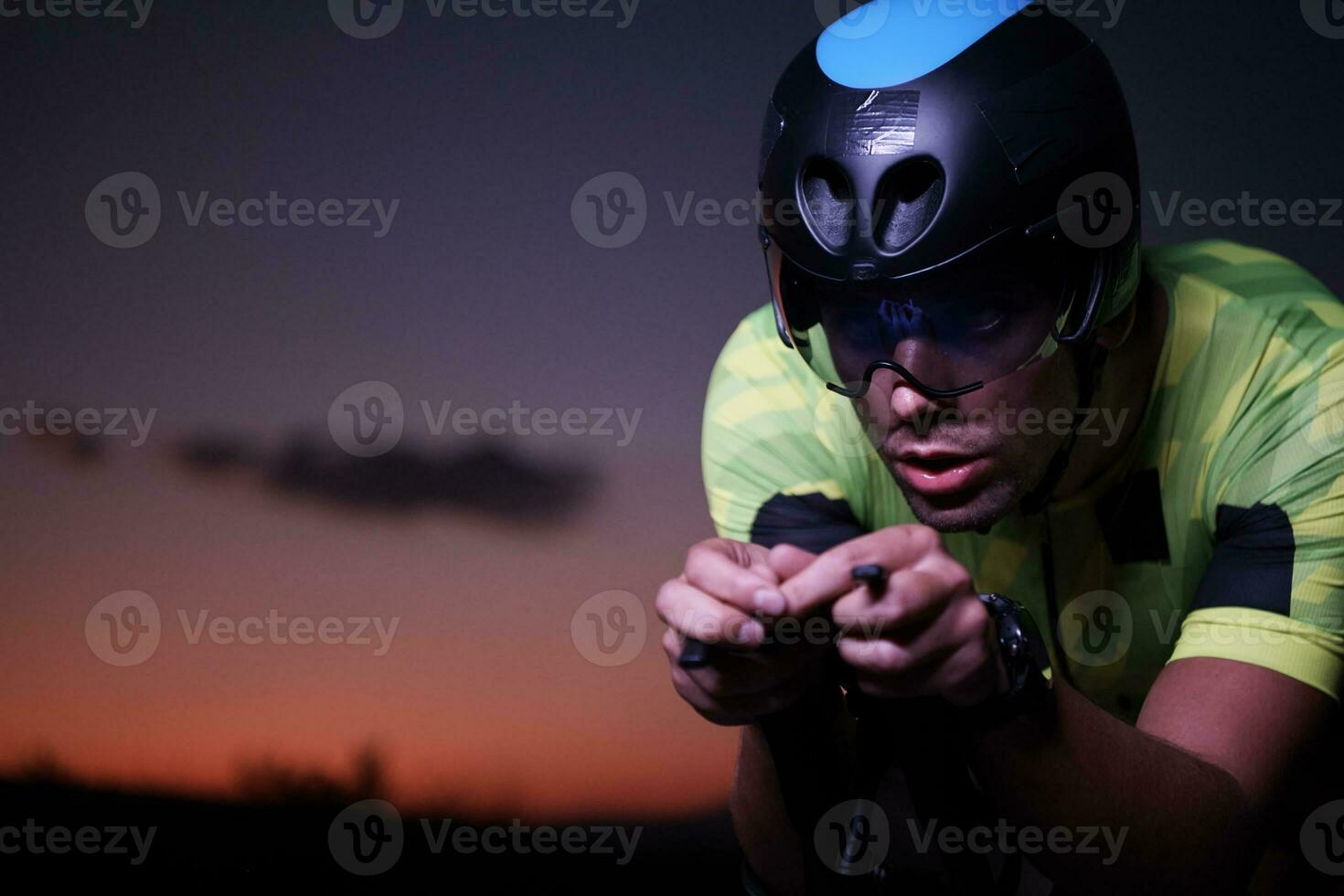 triathlonatlet som cyklar snabbt på natten foto