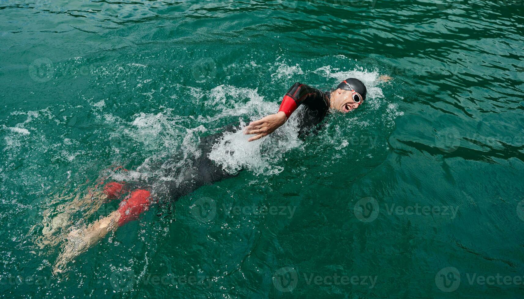 triathlon idrottare simmar på sjön bär våtdräkt foto