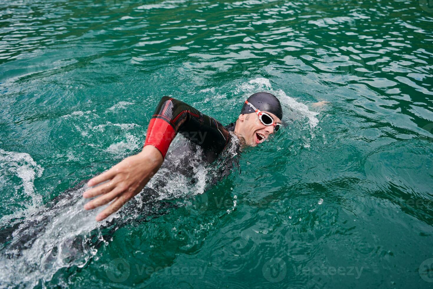 triathlon idrottare simmar på sjön bär våtdräkt foto