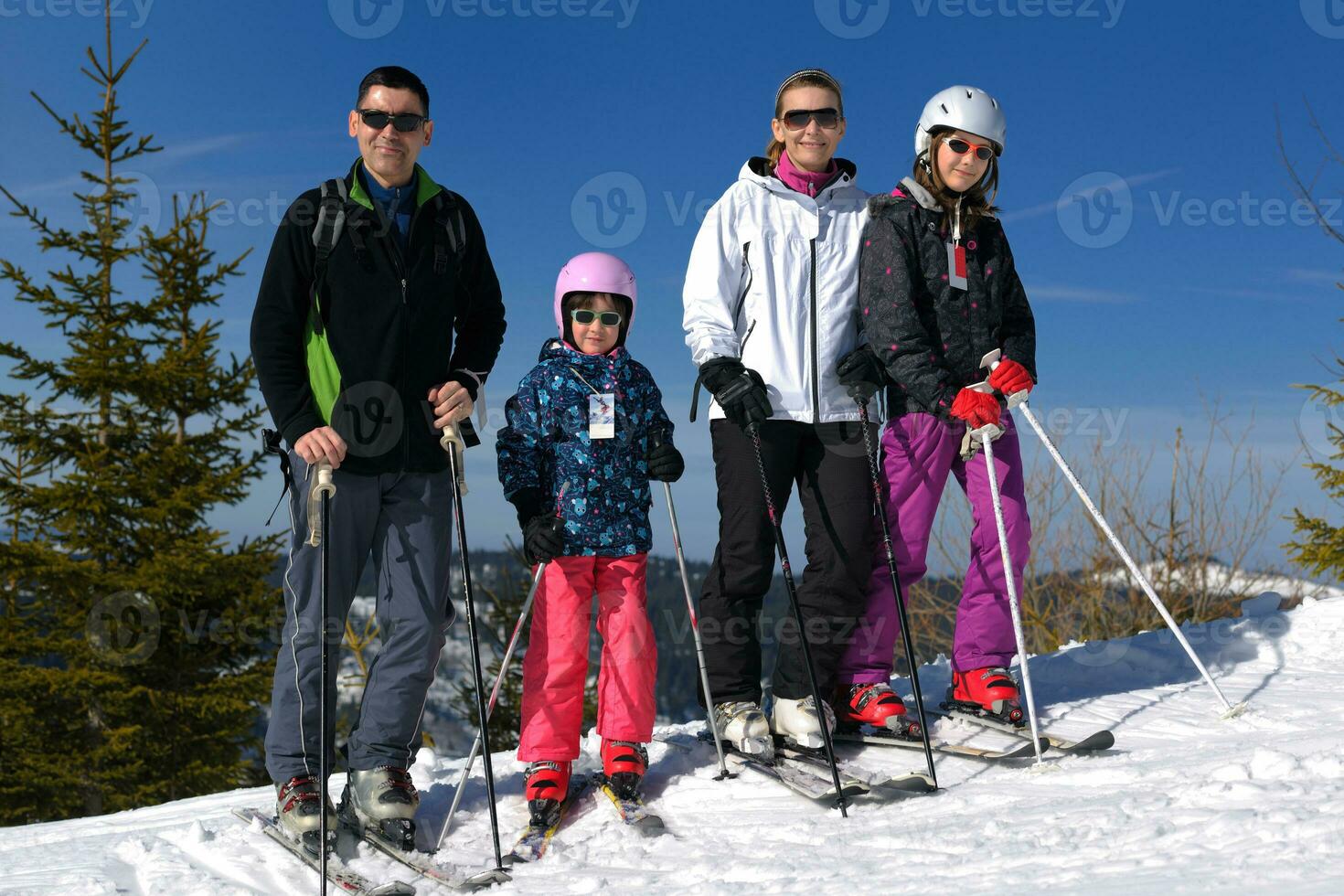 porträtt av Lycklig ung familj på vinter- foto