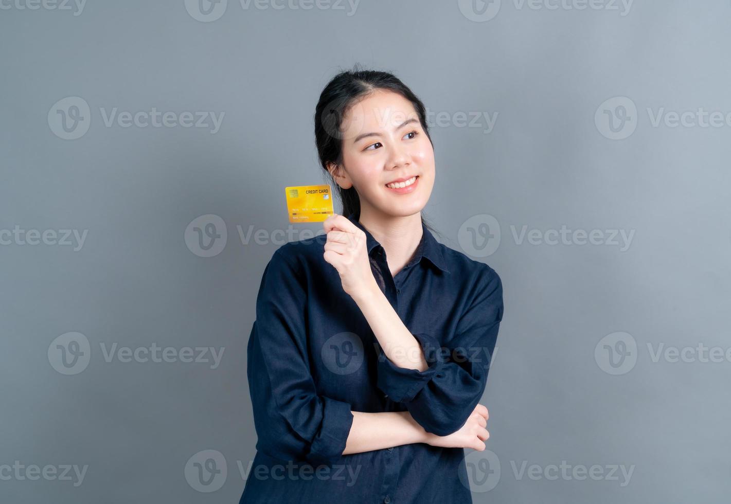 stående av en härlig ung asiatisk kvinna som visar kreditkort foto